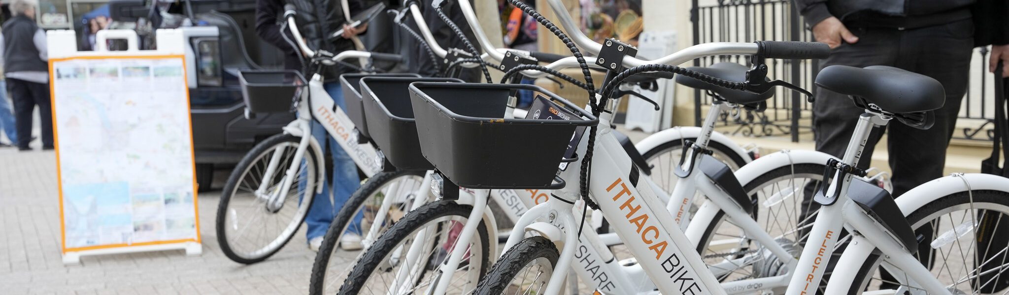 Several white and orange Ithaca BikeShare bikes